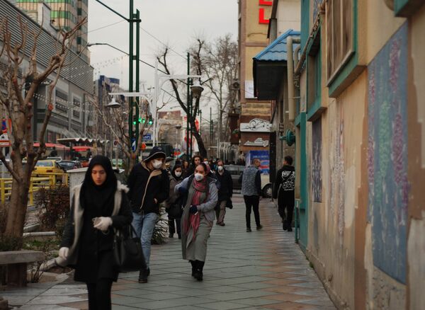 Люди в медицинских масках на улице столицы Ирана города Тегеран Люди в медицинских масках на улице столицы Ирана города Тегеран