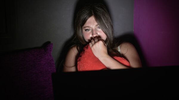 Девушка смотрит ночью фильм на ноутбуке