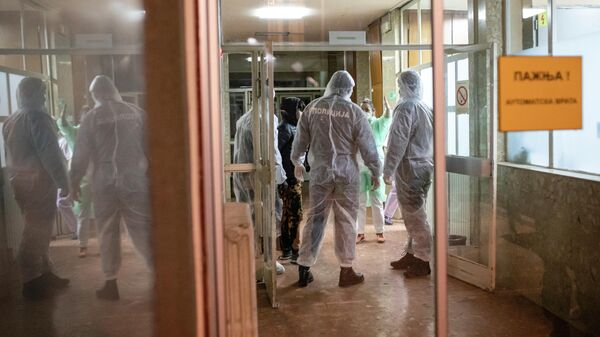 Полицейские в защитных костюмах в инфекционной больнице в Белграде Полицейские в защитных костюмах в инфекционной больнице в Белграде