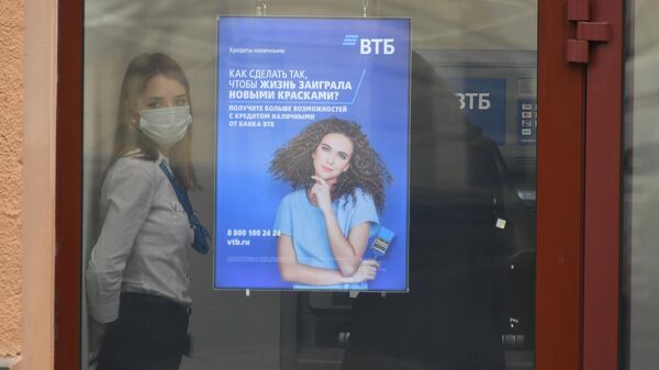 Сотрудница в защитной маске в отделении банка ВТБ на одной из улиц в Москве