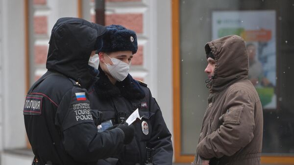 Сотрудники полиции проверяют документы прохожего на улице в Москве Сотрудники полиции проверяют документы прохожего на улице в Москве