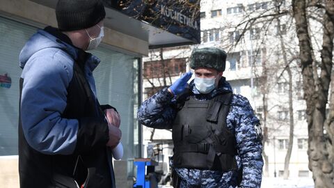 Сотрудник Росгвардии во время раздачи горожанам памяток по профилактике коронавирусной инфекции на одной из улиц в Москве Сотрудник Росгвардии во время раздачи горожанам памяток по профилактике коронавирусной инфекции на одной из улиц в Москве