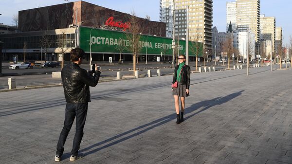 Молодые люди фотографируются на улице Новый Арбат в Москве Молодые люди фотографируются на улице Новый Арбат в Москве