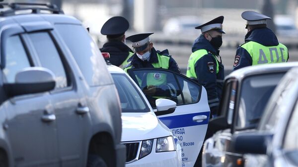 Сотрудники ГИБДД проверяют автомобили на въезде в Москву Сотрудники ГИБДД проверяют автомобили на въезде в Москву