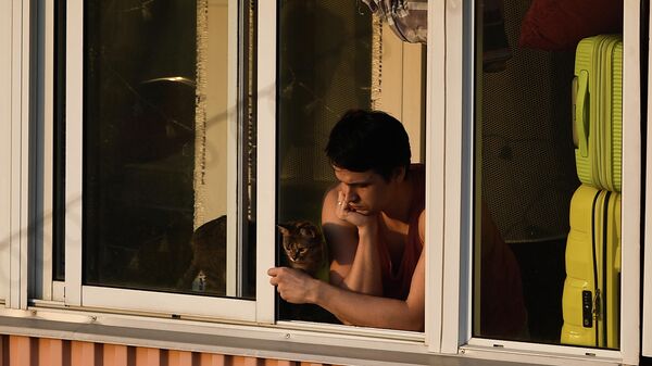 Молодой человек на балконе многоквартирного дома Молодой человек на балконе многоквартирного дома