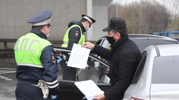 Сотрудники ГИБДД во время проверки электронных пропусков у водителей на блокпосту при въезде в Москву Сотрудники ГИБДД во время проверки электронных пропусков у водителей на блокпосту при въезде в Москву