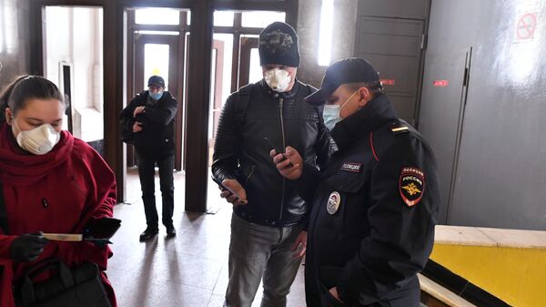 Пассажир метро показывает код своего электронного пропуска на экране смартфона сотруднику полиции на станции метро Сокольники в Москве Пассажир метро показывает код своего электронного пропуска на экране смартфона сотруднику полиции на станции метро Сокольники в Москве