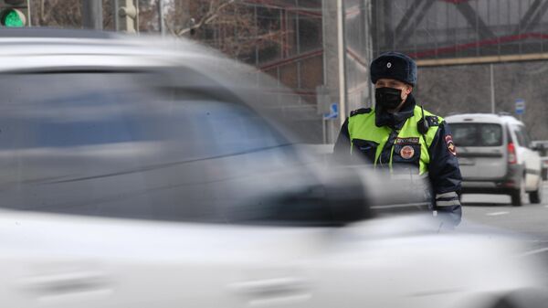 Инспектор дорожно-патрульной службы во время проверки наличия цифрового пропуска на передвижение по Москве Инспектор дорожно-патрульной службы во время проверки наличия цифрового пропуска на передвижение по Москве