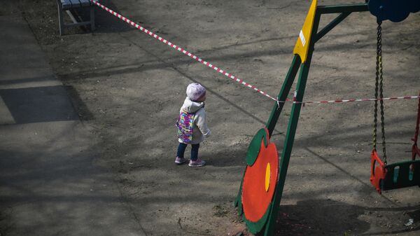 Ребенок на детской площадке во дворе на одной из улиц в Москве Ребенок на детской площадке во дворе на одной из улиц в Москве