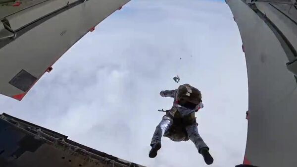 Российские десантники совершают групповое десантирование с самолета Ил-76 на новых парашютных системах с высоты 10 000 метров в экстремальных условиях Арктики в районе архипелага Земля Франца Иосифа. Стоп-кадр видео Российские десантники совершают групповое десантирование с самолета Ил-76 на новых парашютных системах с высоты 10 000 метров в экстремальных условиях Арктики в районе архипелага Земля Франца Иосифа. Стоп-кадр видео