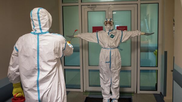 Врачи проходят дезинфекцию в выходном шлюзе госпиталя для зараженных коронавирусом Врачи проходят дезинфекцию в выходном шлюзе госпиталя для зараженных коронавирусом