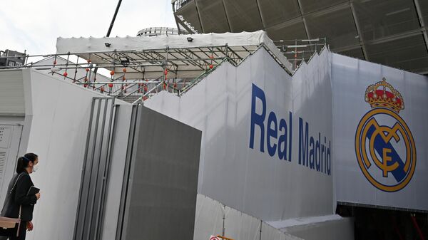A woman wearing a protective face mask arrives at the Santiago Bernabeu stadium in Madrid as Real Madrid players went into quarantine due to the coronavirus outbreak, on March 12, 2020. - Spain's top two divisions will be suspended for at least two weeks over the coronavirus. La Liga authorities made the decision after Real Madrid confirmed its senior football team is in quarantine after one of the club's basketball players tested positive for the virus. (Photo by GABRIEL BOUYS / AFP)