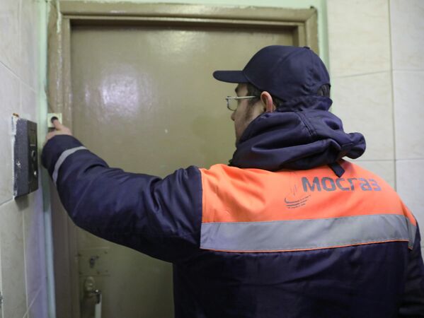 Сотрудник газовой службы звонит в дверь Сотрудник газовой службы звонит в дверь