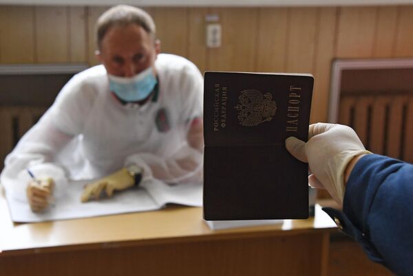 Курсант Морского государственного университета имени адмирала Г. И. Невельского предъявляет свой паспорт во время голосования по вопросу одобрения изменений в Конституцию России во Владивостоке Курсант Морского государственного университета имени адмирала Г. И. Невельского предъявляет свой паспорт во время голосования по вопросу одобрения изменений в Конституцию России во Владивостоке