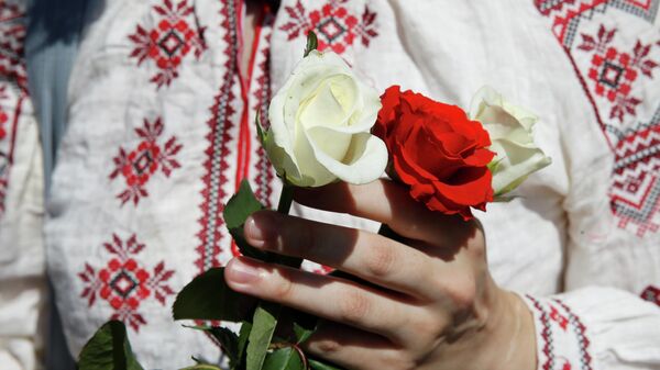 Женщина держит розы во время митинга в поддержку белорусской оппозиции в центре Киева