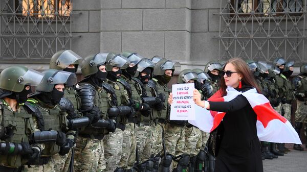 Участница акции протеста и сотрудники правоохранительных органов на проспекте Независимости в Минске Участница акции протеста и сотрудники правоохранительных органов на проспекте Независимости в Минске