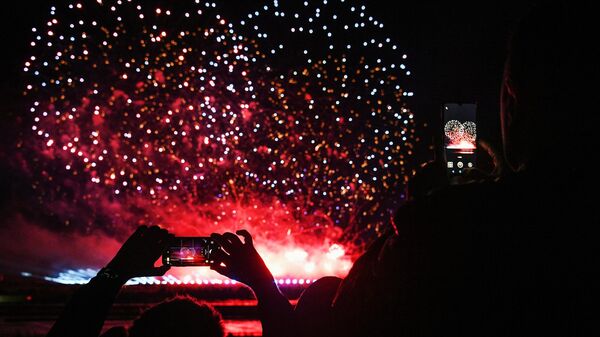 Люди фотографируют на мобильные телефоны салют на международном фестивале фейерверков Ростех, который проходит на территории парка Патриот. Люди фотографируют на мобильные телефоны салют на международном фестивале фейерверков Ростех, который проходит на территории парка Патриот.