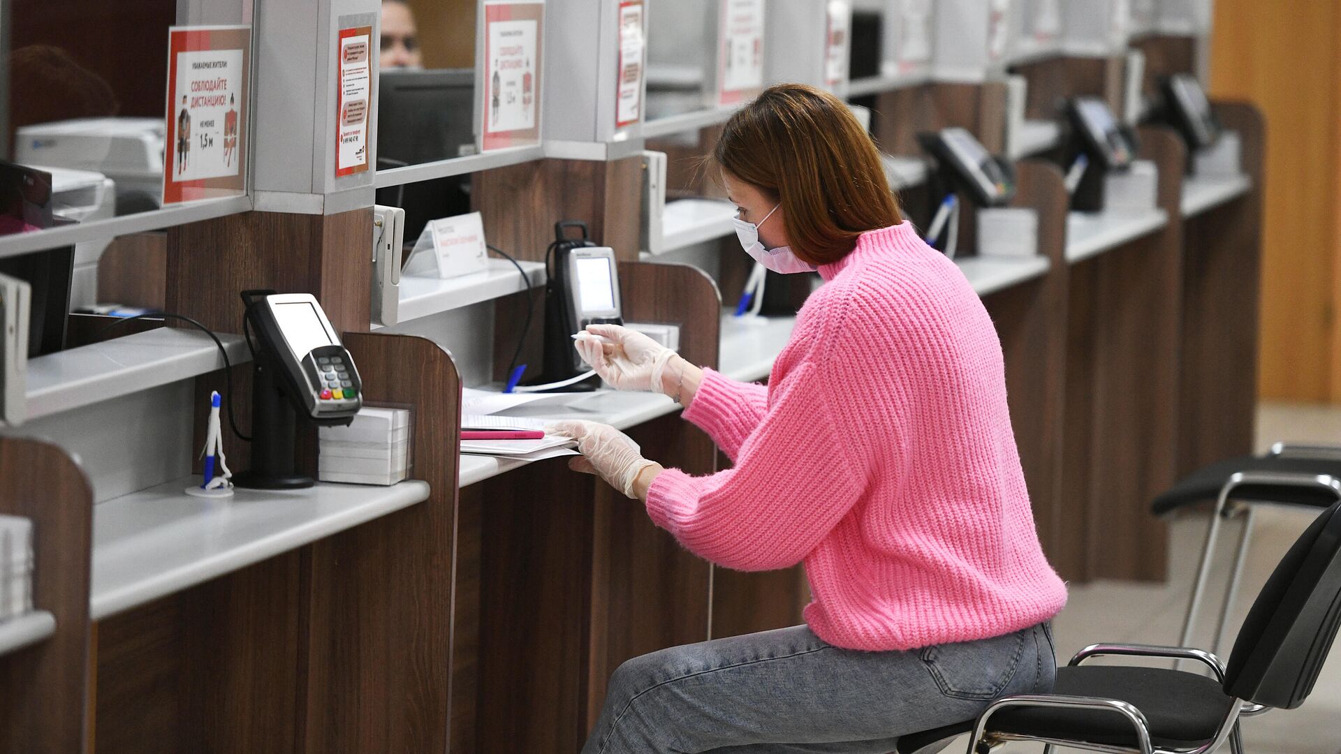 Посетительница в многофункциональном центре государственных и муниципальных услуг Посетительница в многофункциональном центре государственных и муниципальных услуг - РИА Новости, 1920, 08.04.2021