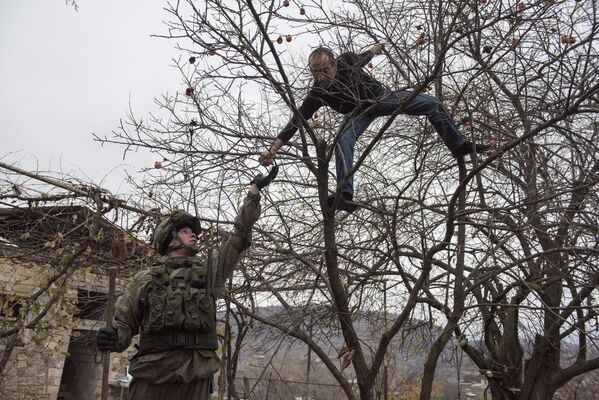 Местный житель угощает специалиста Международного противоминного центра Минобороны России гранатом вблизи Степанакерта в Нагорном Карабахе Местный житель угощает специалиста Международного противоминного центра Минобороны России гранатом вблизи Степанакерта в Нагорном Карабахе