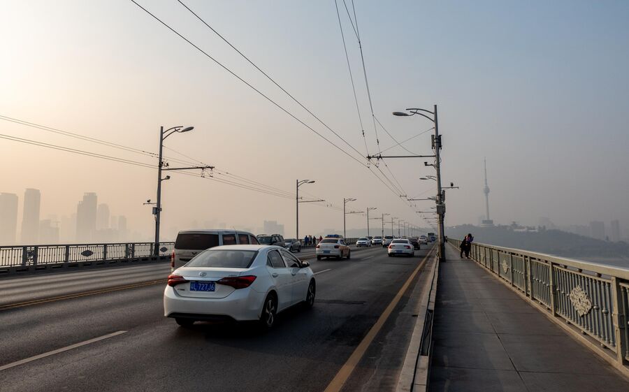 Движение автомобилей на одной из дорог в Ухани Движение автомобилей на одной из дорог в Ухани