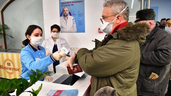 Измерение температуры при входе в пункт вакцинации от коронавируса в ГУМе в Москве Измерение температуры при входе в пункт вакцинации от коронавируса в ГУМе в Москве