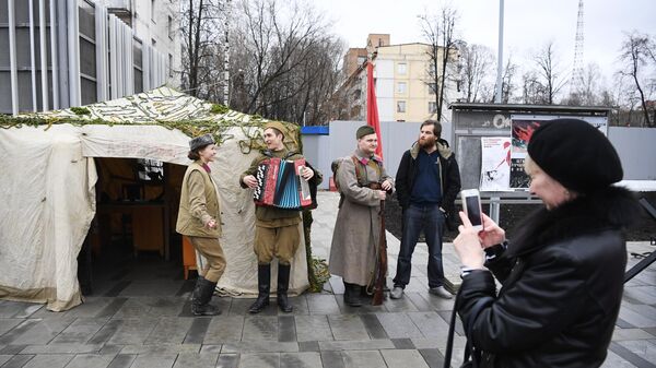 Женщина фотографирует артистов у станции Народное ополчение Большой кольцевой линии московского метрополитена. Женщина фотографирует артистов у станции Народное ополчение Большой кольцевой линии московского метрополитена.