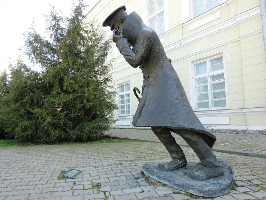 Памятник Человеку в футляре из одноименного произведения Антона Чехова перед гимназией Памятник Человеку в футляре из одноименного произведения Антона Чехова перед гимназией