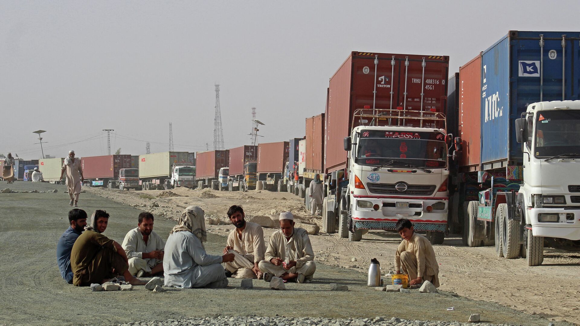 Водители сидят рядом со своими контейнеровозами, ожидая въезда в Афганистан в пограничном с Пакистаном городе Чаман  - РИА Новости, 1920, 02.09.2021