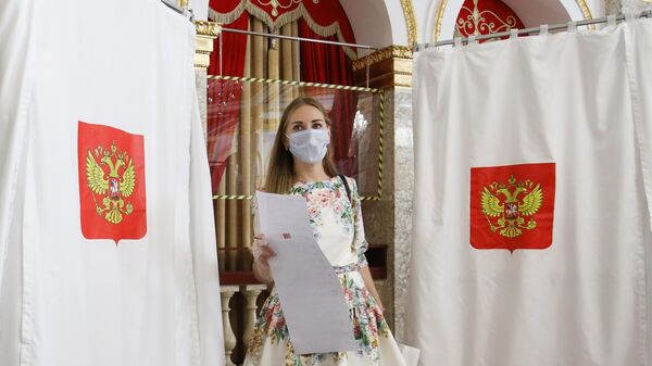 Девушка голосует на избирательном участке №20-10 в Краснодаре Девушка голосует на избирательном участке №20-10 в Краснодаре