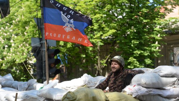 Активист сил самообороны сторонников федерализации Украины на баррикаде под флагом ДНР Активист сил самообороны сторонников федерализации Украины на баррикаде под флагом ДНР