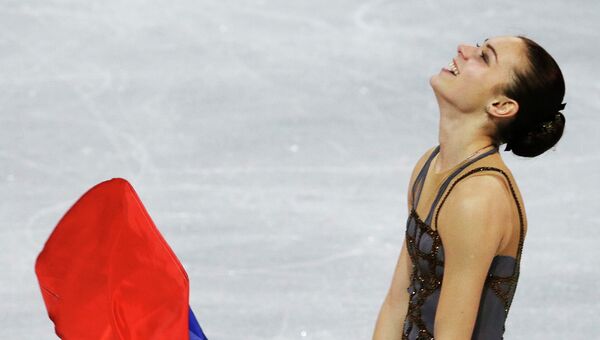 Аделина Сотникова с флагом России после выступления на Олимпийских играх в Сочи. Архивное фото Аделина Сотникова с флагом России после выступления на Олимпийских играх в Сочи. Архивное фото