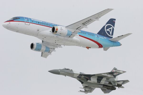 Самолет Sukhoi SuperJet-100 (вверху) в сопровождении истребителя Су-35 (внизу) Самолет Sukhoi SuperJet-100 (вверху) в сопровождении истребителя Су-35 (внизу)