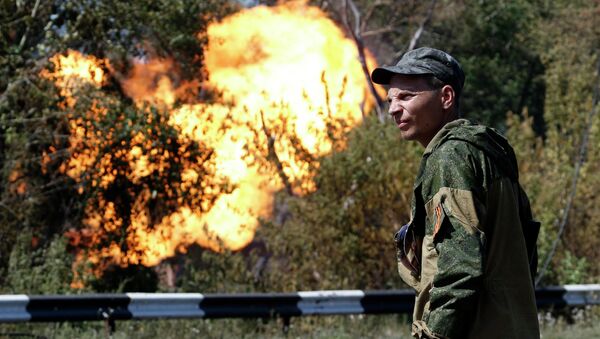 Боец народного ополчения возле газопровода, который загорелся в результате обстрела Донецка 15 августа 2014 Боец народного ополчения возле газопровода, который загорелся в результате обстрела Донецка 15 августа 2014