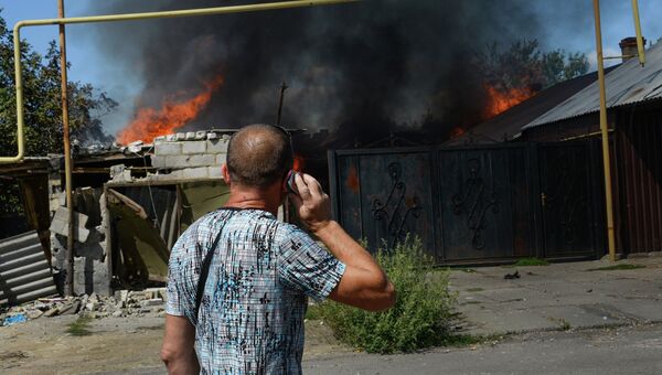 Мужчина у горящего дома в Петровском районе Донецка. Архивное фото Мужчина у горящего дома в Петровском районе Донецка. Архивное фото