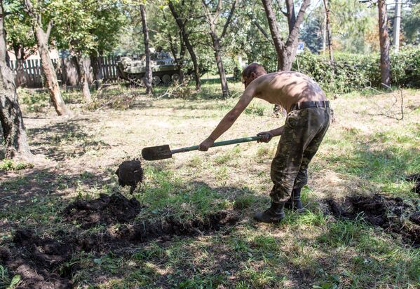 Пленный украинский военный роет могилу для погибших сослуживцев в результате боев в городе Шахтерск под Донецком Пленный украинский военный роет могилу для погибших сослуживцев в результате боев в городе Шахтерск под Донецком