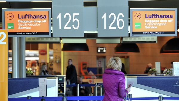 Пассажирка стоит у стойки регистрации авиакомпании Lufthansa Пассажирка стоит у стойки регистрации авиакомпании Lufthansa