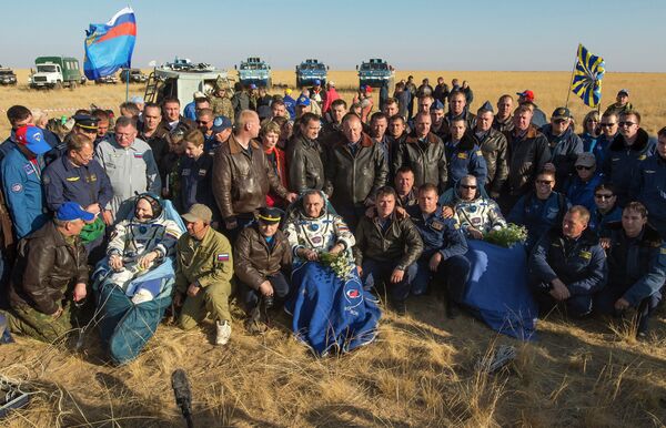 Члены 40 экспедиции на МКС после приземления с членами спасательного отряда Члены 40 экспедиции на МКС после приземления с членами спасательного отряда