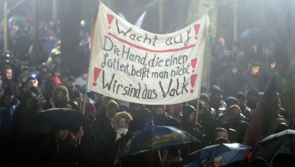 Участники акции протеста в Германии, выступающие против нетерпимости в отношении иммигрантов и движения Pegida Участники акции протеста в Германии, выступающие против нетерпимости в отношении иммигрантов и движения Pegida