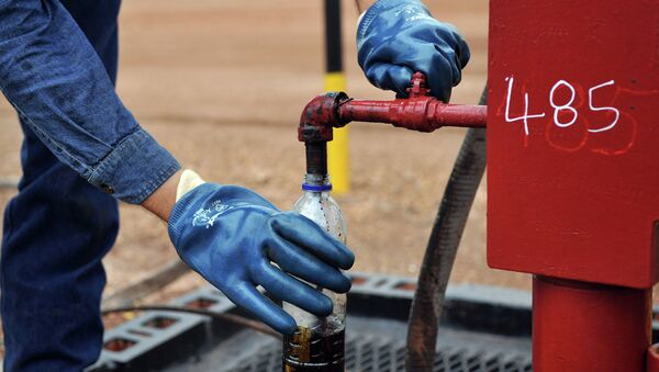 Инженер берет образец нефти на одной из скважин Инженер берет образец нефти на одной из скважин