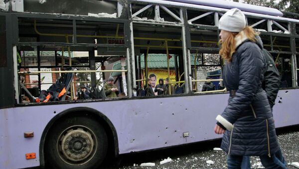 Девушка проходит мимо обстрелянного троллейбуса в Донецке Девушка проходит мимо обстрелянного троллейбуса в Донецке