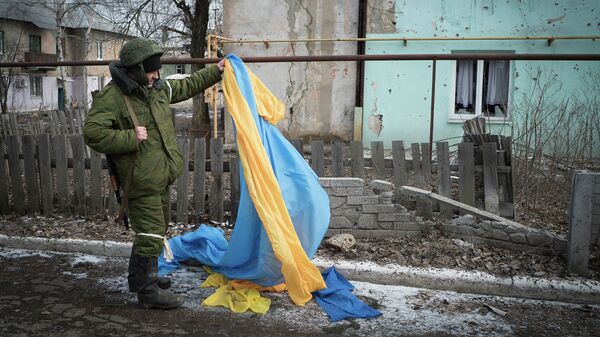 Ополченец держит флаг Украины, брошенный украинскими военными в Углегорске
