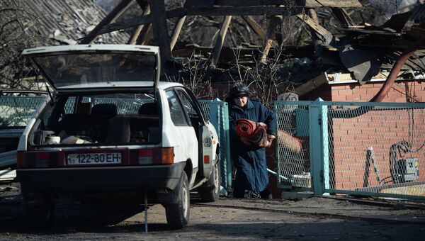 Женщина выносит вещи из своего разрушенного дома в поселке Октябрьский рядом с аэропортом города Донецка. Архивное фото Женщина выносит вещи из своего разрушенного дома в поселке Октябрьский рядом с аэропортом города Донецка. Архивное фото