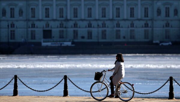 Девушка едет на велосипеде по Набережной Невы в Санкт-Петербурге. Архивное фото Девушка едет на велосипеде по Набережной Невы в Санкт-Петербурге. Архивное фото