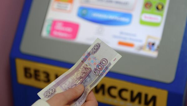Жительница Москвы производит оплату услуг в одном из платежных терминалов QIWI. Архивное фото Жительница Москвы производит оплату услуг в одном из платежных терминалов QIWI. Архивное фото