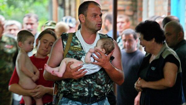Боец спецназа несет спасенного ребенка во время штурма захваченной боевиками школы в Беслане. 2004 год Боец спецназа несет спасенного ребенка во время штурма захваченной боевиками школы в Беслане. 2004 год