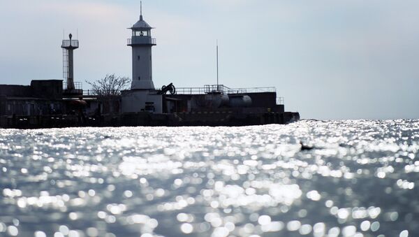 Маяк городского порта Ялты в акватории Черного моря. Архивное фото Маяк городского порта Ялты в акватории Черного моря. Архивное фото