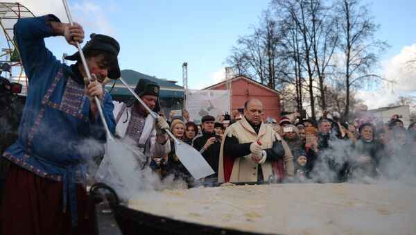 Участники масленичных гуляний во время установления рекорда по приготовлению самого большого блина России в саду Эрмитаж в Москве Участники масленичных гуляний во время установления рекорда по приготовлению самого большого блина России в саду Эрмитаж в Москве