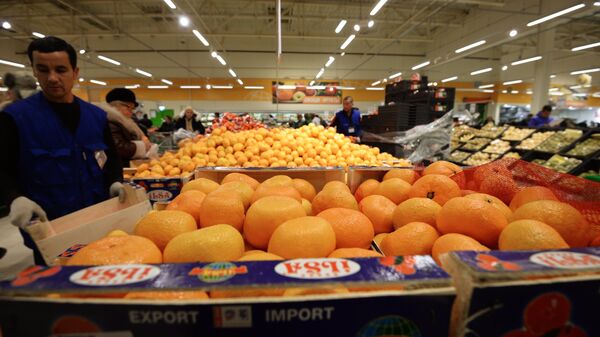 Продавец у прилавка с мандаринами из Турции Продавец у прилавка с мандаринами из Турции