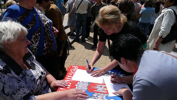 Жительница Донецка во время митинга подписывает петицию против нарушения Киевом резолюции Совета безопасности ООН Жительница Донецка во время митинга подписывает петицию против нарушения Киевом резолюции Совета безопасности ООН