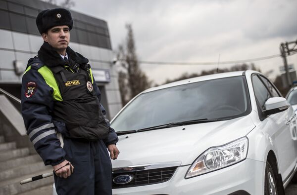 Сотрудник ГИБДД рядом с автомобилем без специальных знаков и проблескового маячка во время рейда скрытых патрулей ДПС в Москве Сотрудник ГИБДД рядом с автомобилем без специальных знаков и проблескового маячка во время рейда скрытых патрулей ДПС в Москве